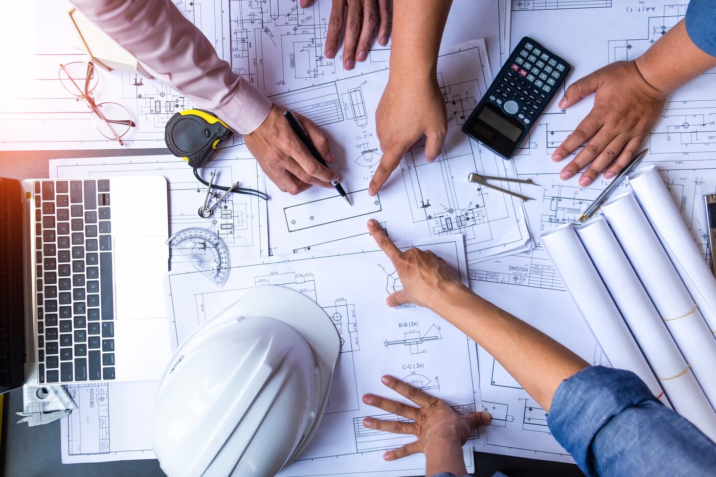 Engineers working over drawings and calculations